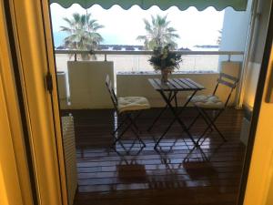 a room with a table and chairs and a balcony with palm trees at FronteMare Luxury in Montesilvano