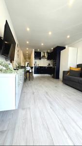 Una sala de estar y cocina con piso de madera y una sala de estar. en 524 Ocean Dreams Las Americas, en Playa de las Américas 28 fotos más