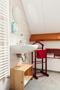 a bathroom with a sink and a red chair at B7 Selfkant in Selfkant