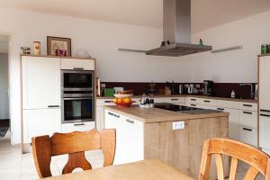 a kitchen with white cabinets and a table and chairs at B7 Selfkant in Selfkant