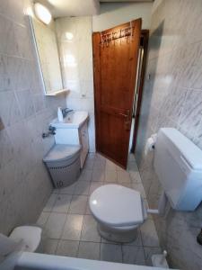 Un baño con inodoro, lavabo y espejo. en Lena Summer Sea Family Vacation House & Yard Chalkidiki, en Sozopoli