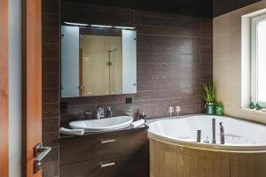 un bagno con vasca, lavandino e specchio di Apartament z Jacuzzi Parking Balkon 2 sypialnie a Breslavia Altre 25 foto
