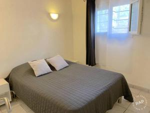 a bedroom with a bed with two pillows and a window at Les lauriers fleurs in Lecci