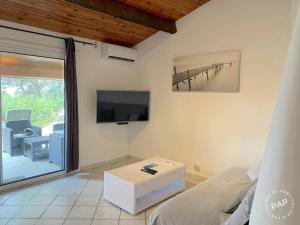 a living room with a bed and a tv at Les lauriers fleurs in Lecci