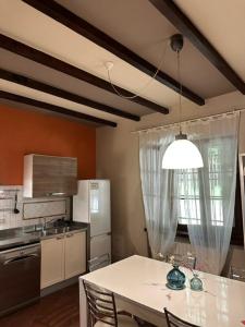 a kitchen with a table with chairs and a refrigerator at Casa Vacanza Indipendente Cascina Cremasca with pool in Crema
