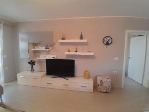un salon avec une télévision à écran plat sur une armoire dans l'établissement Cufaj Apartaments Shkodra, à Shkodër
