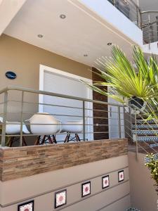 a balcony with white chairs and plants in a house at La Terra Luxury apartment in Kivérion +18 photos