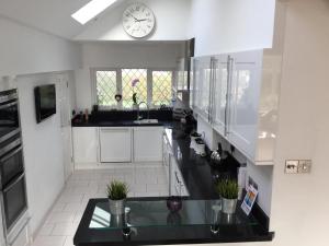 a large kitchen with a clock on the wall at Ragged Hall Lane in Saint Albans