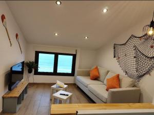 a living room with a couch and a table at BURELA Mariña PLAYA in Burela de Cabo
