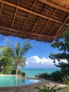 a swimming pool with a view of the ocean at Amani - Private Ocean House with Pool in Kikungwi