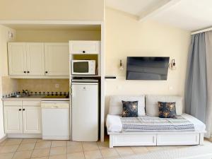 a small kitchen with a couch and a microwave at AZUR APPARTEMENT (SEA VIEW) LES RESTANQUES DE ST-TROPEZ1131 in Grimaud