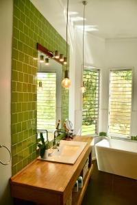 a bathroom with a sink and a tub and green tiles at Birds Heaven Mareeba in Mareeba +9 photos