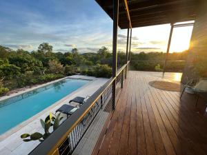 a deck with a swimming pool on a house at Birds Heaven Mareeba in Mareeba