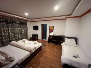 a hotel room with two beds and a television at Dream Ladakh Guest House in Leh