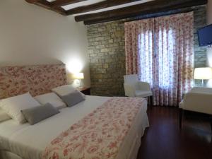 Un dormitorio con una cama grande en una habitación. en Los Arcos, en Aínsa