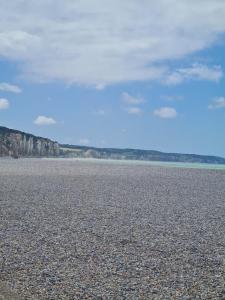 a large body of water with a rocky beach at Tiny House in Varneville-Bretteville +2 photos