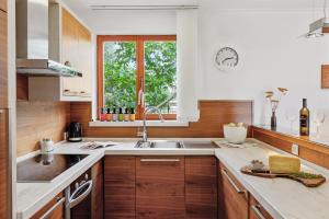 a kitchen with wooden cabinets and a sink and a window at Villa Umag Istria seaview private pool and garage by Rentistra in Umag