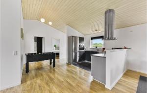 a living room with a piano and a kitchen at Holiday Home Sydmarken Xi in Falen