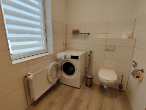 a bathroom with a washing machine and a toilet at Wohlfühl-Wohnungen im Herzen von Clausthal in Clausthal-Zellerfeld