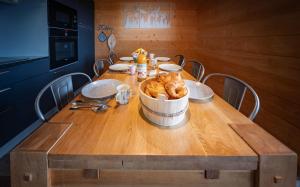 a wooden table with a bowl of food on it at Chalet La Souris, chaleureux avec vue panoramique in Gérardmer