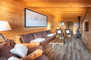 a living room with a couch and a table at Chalet La Souris, chaleureux avec vue panoramique in Gérardmer