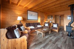 a living room with couches and a fireplace at Chalet La Souris, chaleureux avec vue panoramique in Gérardmer
