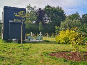 a garden with a table and chairs and a tree at Tiny House in Varneville-Bretteville