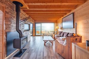 a living room with a fireplace in a log cabin at Chalet La Souris, chaleureux avec vue panoramique in Gérardmer