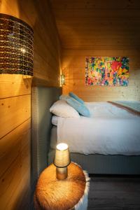 a bedroom with a bed and a table with a lamp at Chalet La Souris, chaleureux avec vue panoramique in Gérardmer