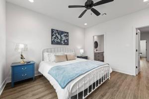 ein Schlafzimmer mit einem weißen Bett und einem Deckenventilator in der Unterkunft Cajun French House-2 King Beds-Near Sports Complex in Lafayette