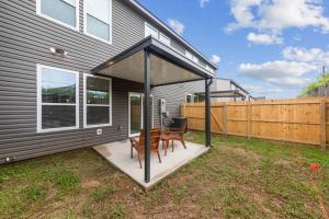 eine überdachte Terrasse mit zwei Stühlen und einem Tisch in der Unterkunft Cajun French House-2 King Beds-Near Sports Complex in Lafayette