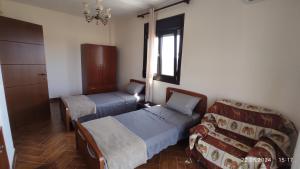 Habitación con 2 camas, sofá y ventana en Kallithea Eco-Village, en Kallithea Halkidikis