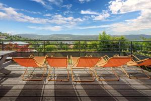a group of chairs sitting on top of a deck at Chalet La Souris, chaleureux avec vue panoramique in Gérardmer