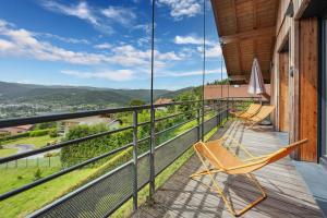 a balcony with chairs and a view of the mountains at Chalet La Souris, chaleureux avec vue panoramique in Gérardmer