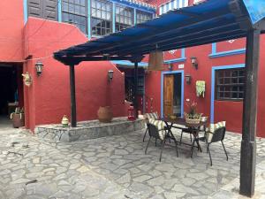 a patio with a table and chairs under a blue umbrella at Villa Perestelo in Los Sauces