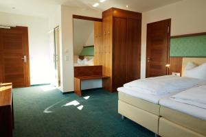 Pfaffing的住宿－法弗英霍夫酒店，配有一张床和一张书桌的酒店客房