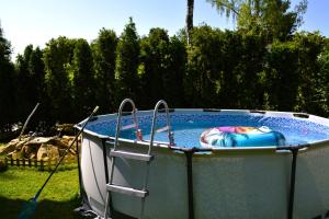 a large hot tub in a yard with at Brama Sanu - z prywatną linią brzegową Jeziora Solińskiego - pomosty - pontony - basen sezonowy in Olchowiec