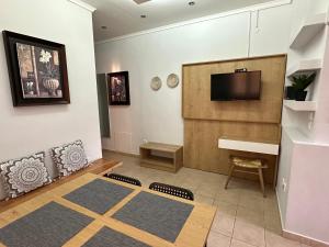 a living room with a tv and a couch and a table at ANNA ROOMS (Villa Anna) in Nea Vrasna