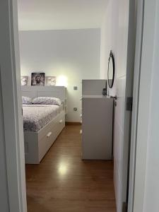 a white bedroom with a bed and a mirror at Yudelmys confort in Las Palmas de Gran Canaria