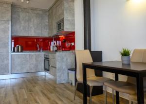 kuchnia z czerwonymi szafkami i stołem z krzesłami w obiekcie Beach Side Apartments Calahonda w mieście Sitio de Calahonda