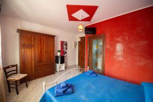 a bedroom with a bed and a red wall at Bed e breakfast Terra e Mare in Sava +7 photos