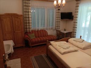 a bedroom with two beds and a couch at Privatzimmer Deutz in Dürnstein in der Steiermark