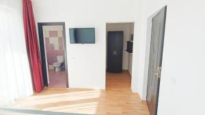 a hallway with two doors and a television on a wall at Portofino Villa in Costinesti