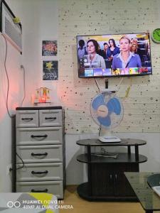 a room with a tv and a table with a fan at CJ’sstaycation in Lapu Lapu in Maribago