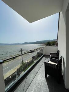 a balcony with two chairs and a view of the water at Relax Residence in Golubac