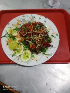 un piatto bianco di cibo su un vassoio rosso di Hotel Darsan and Lodge Taplejung a Tāplejung