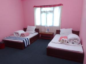 2 letti in una camera con pareti rosa di Hotel Darsan and Lodge Taplejung a Tāplejung