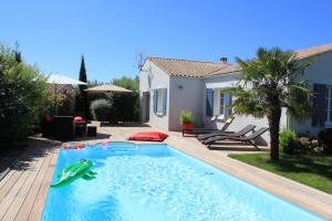 a swimming pool with a toy shark in a backyard at Villa CLOTESS in Dompierre-sur-Mer