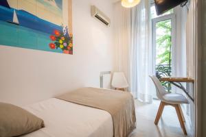 Un dormitorio con una cama y una silla y una ventana. en Pensión Donostiarra, en San Sebastián