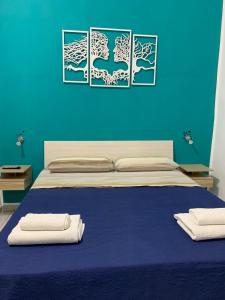 una camera blu con un letto con due asciugamani di DEA PARTHENOPE a Napoli